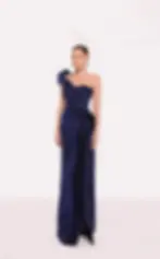 Navy blue pleated one-shoulder evening gown with sculptural draping and a fitted silhouette.