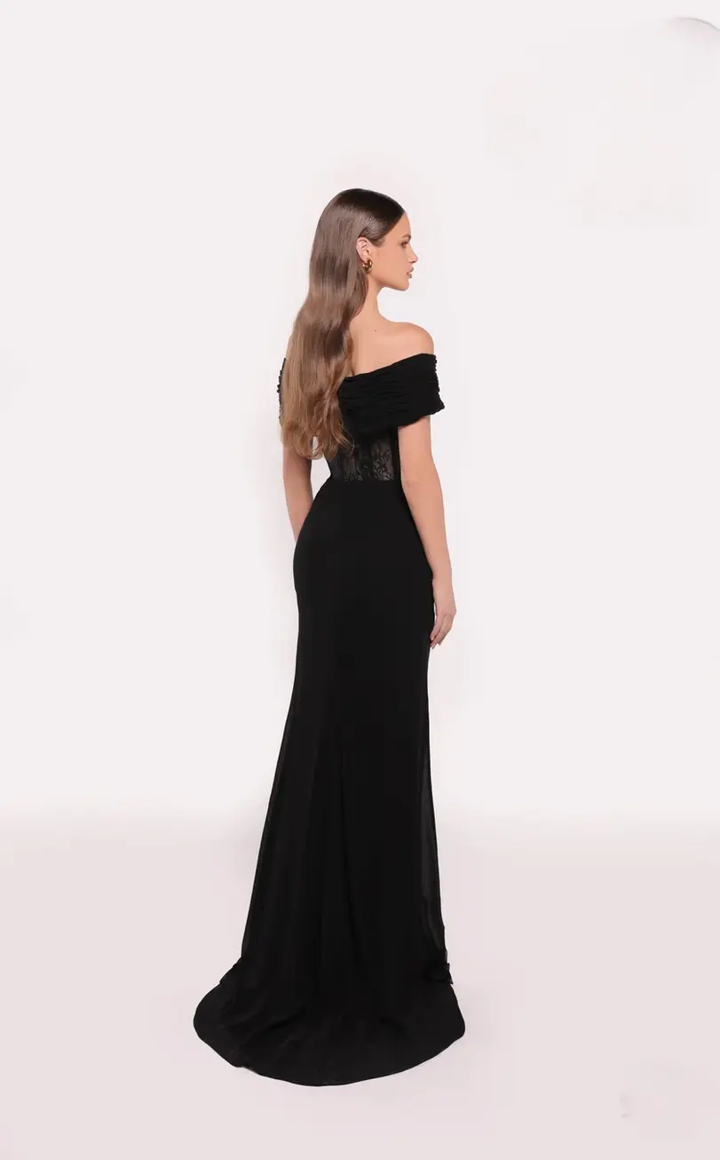 Black off-shoulder evening gown with draped detailing, floral appliqué, and a slit.
