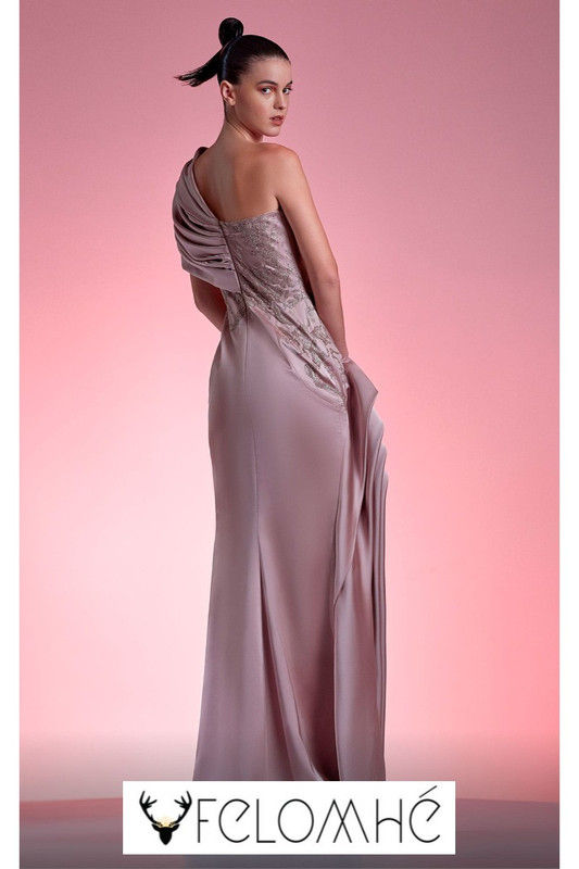 High-fashion blush pink dress featuring an asymmetrical ruffled shoulder, delicate lace embellishments, and a dramatic slit.