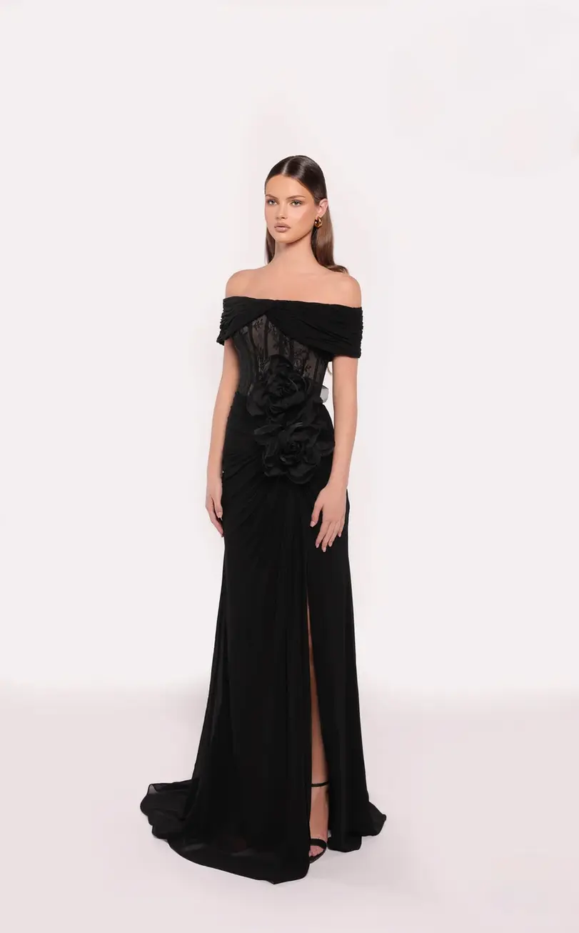 Black off-shoulder evening gown with draped detailing, floral appliqué, and a slit.