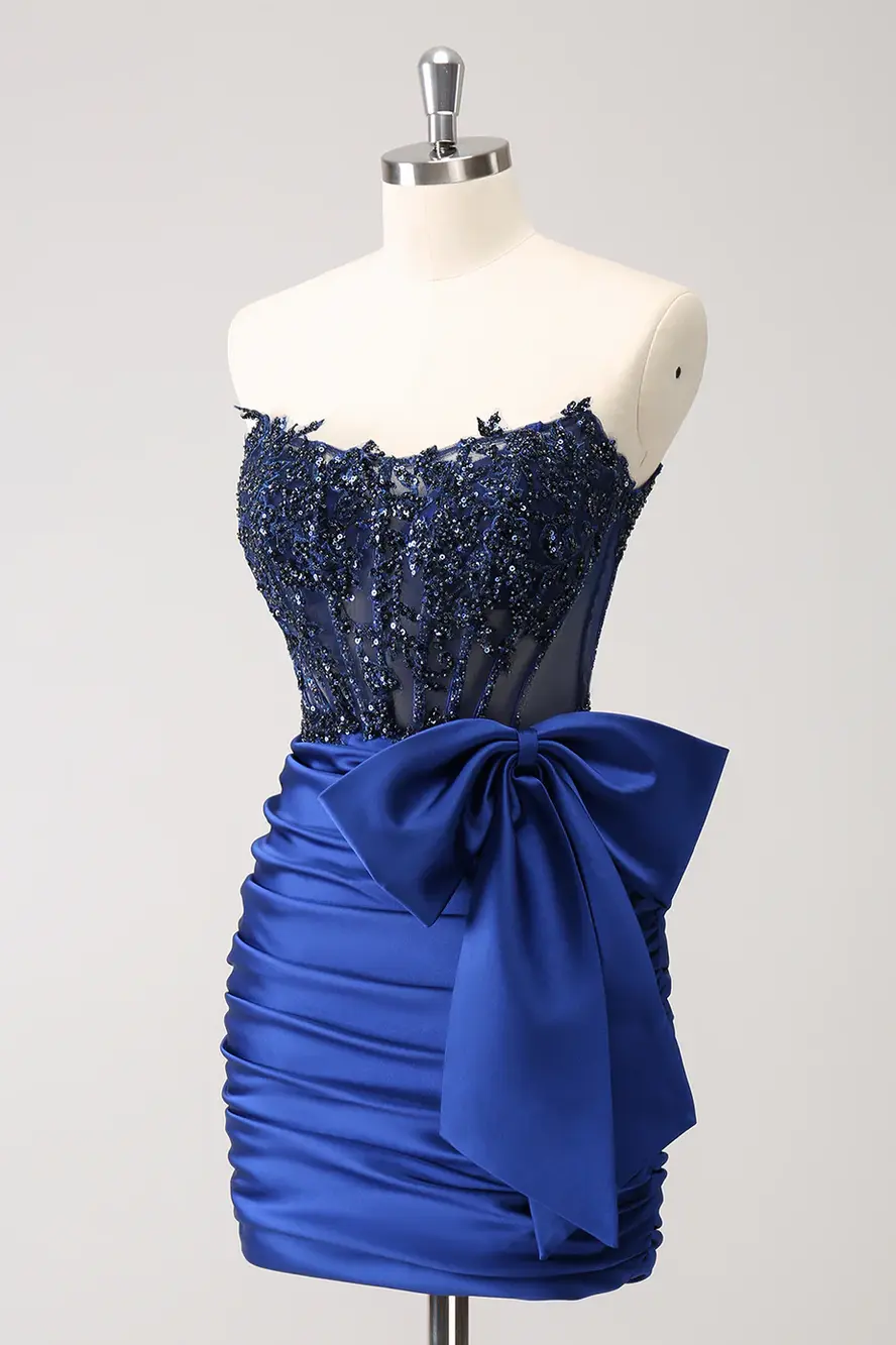 Navy blue embellished corset mini dress with sheer lace bodice, ruched satin skirt, and oversized side bow detail.