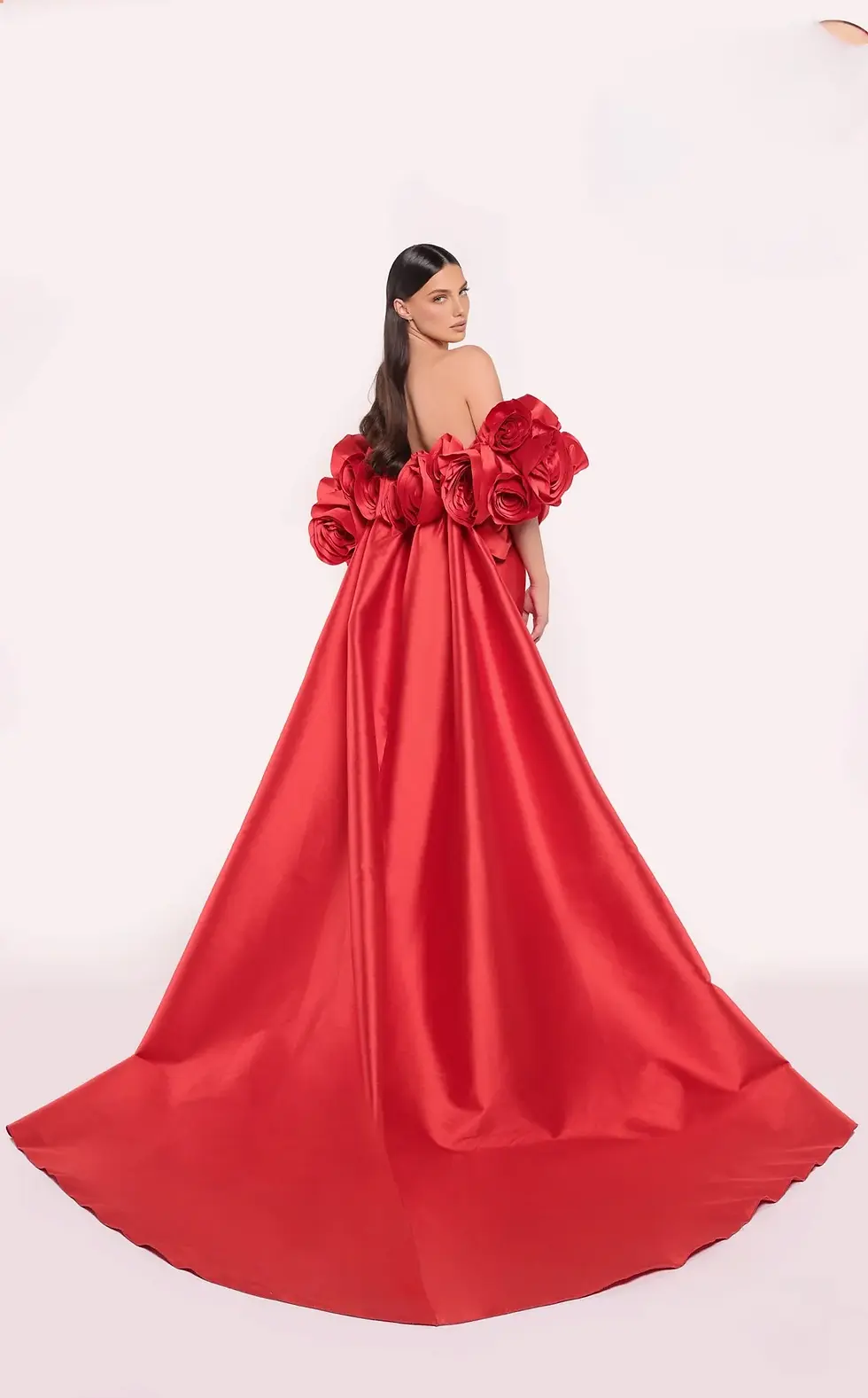 Red corset ball gown with oversized rose-shaped sleeves and a sweeping train.