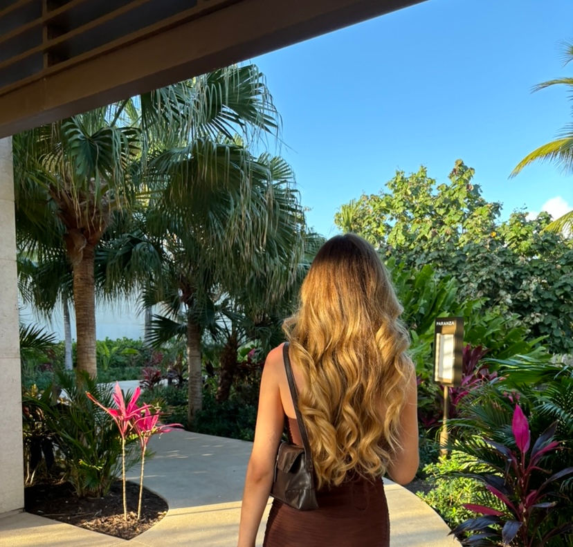 Woman in dark feminine dress, tropical garden.