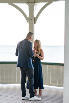 Couple celebrating a surprise proposal at the gazebo in Niagara-on-the-Lake with waterfront views.