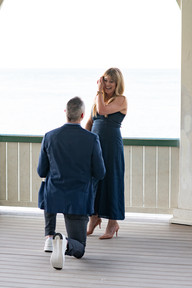 Couple celebrating a surprise proposal at the gazebo in Niagara-on-the-Lake with waterfront views.