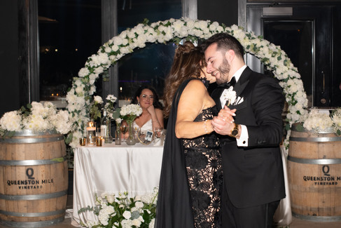 Wedding couple celebrating with family and friends during Niagara vineyard wedding reception.