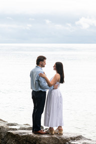 Engagement photos of a happy couple by the lake on a rainy afternoon.