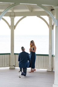 Man getting down on one knee during a surprise proposal at the Niagara-on-the-Lake gazebo.