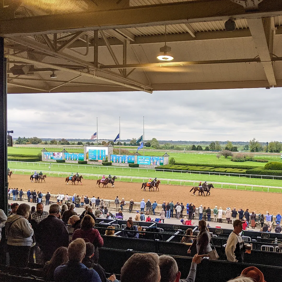 Horses parading on the red dirt race track at Keeneland Race Track before a race