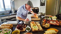 Cheffrey scoops roasted red pepper cream cheese into a home made bread bowl.