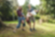mother and father holding children upside down 