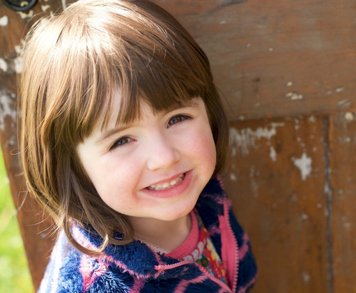 a young girl with strained smile in a photo