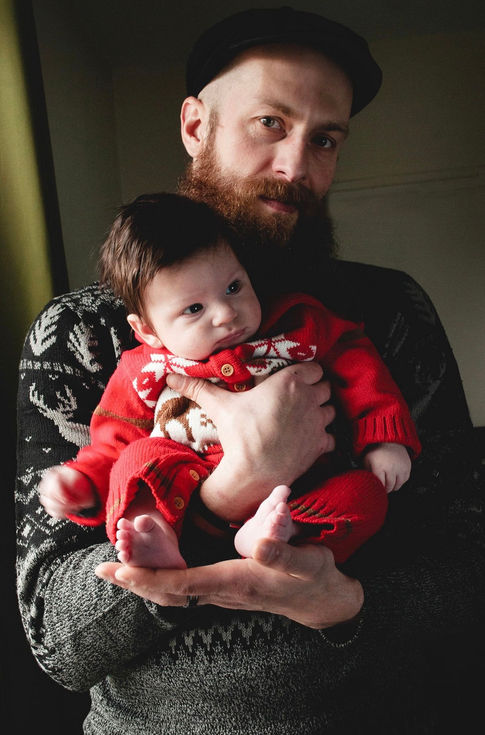 father holding baby son at christmas time