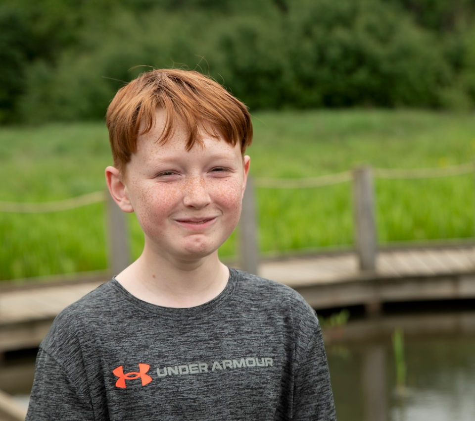 young boy trying not to laugh in family photo