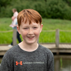 young boy smirking in family photo