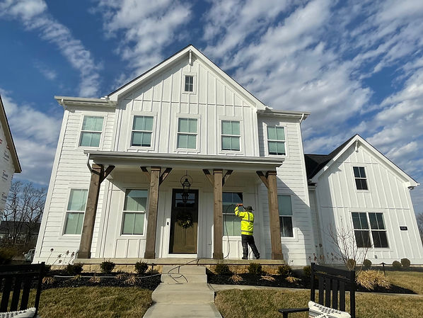 A man powr washing the front exterior of a house
