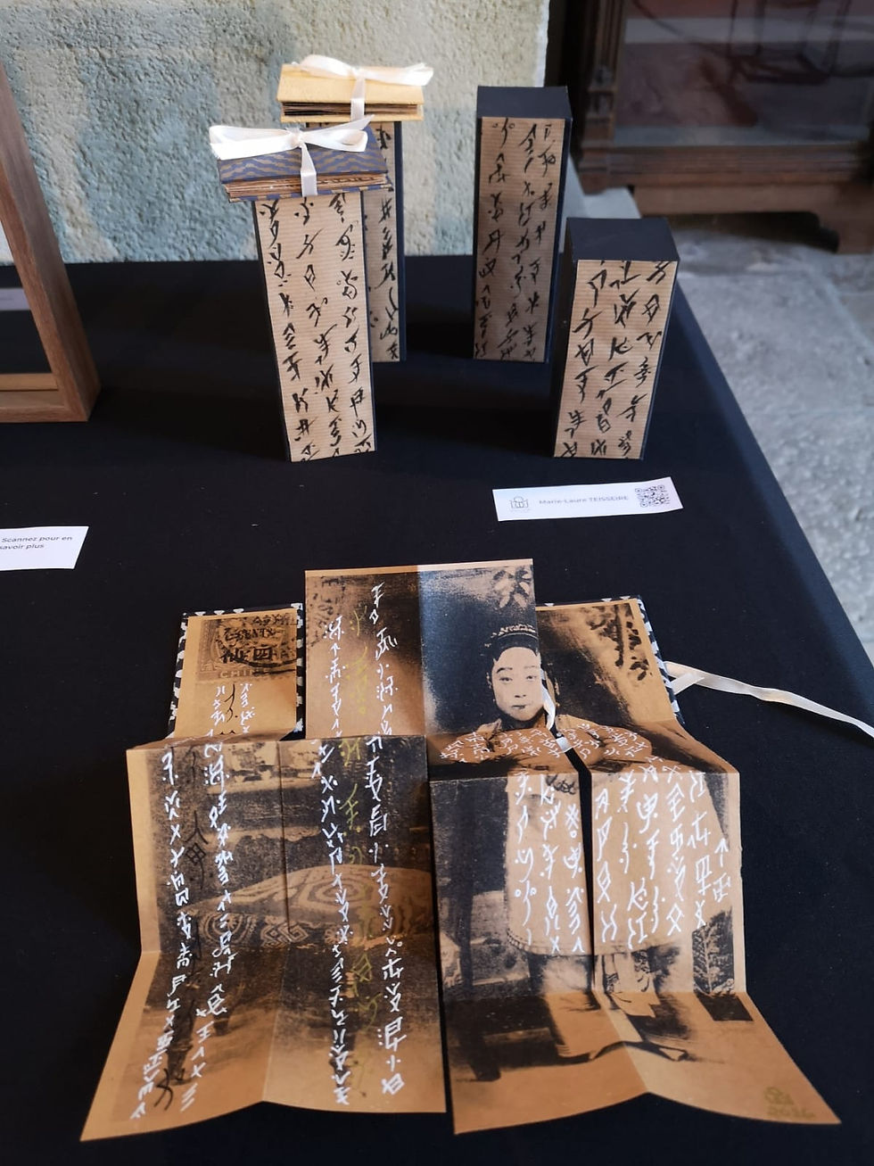 Installation de Marie-Laure Teisseire évoquant les carnets du troisième jour, avec des petits carnets et des boîtes recouverts de calligraphie Nüshu.