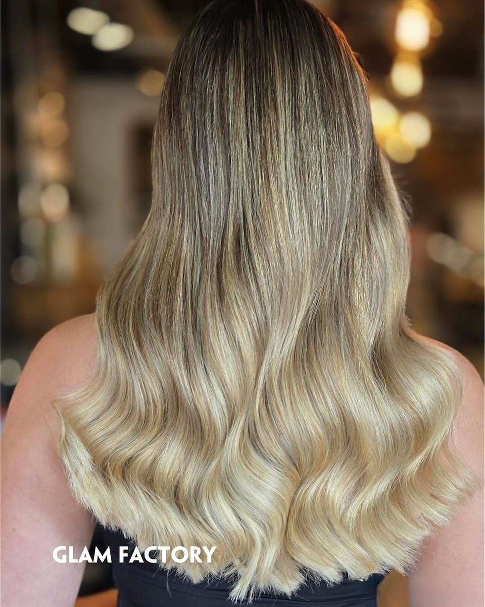 Close-up view of a stylist painting balayage colour onto sectioned hair