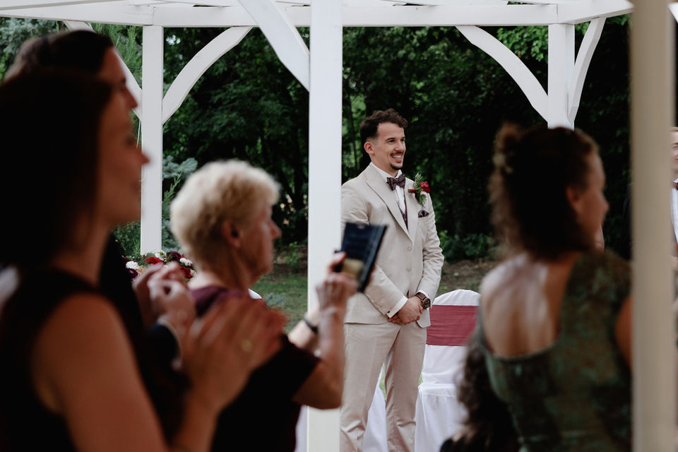 Wedding guests seated under a white pavilion during a Budapest ceremony.