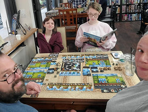 couple playing a story based board game with their 2 daughters