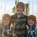 Portrait von drei Jungs, Geschwister, draußen im Feld