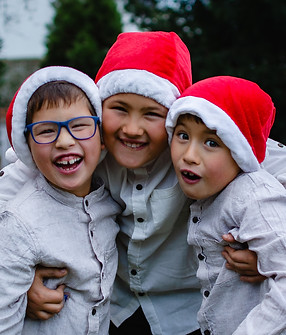 Geschwisterfoto für Weihnachten, Jungs mit Nikolausmützen