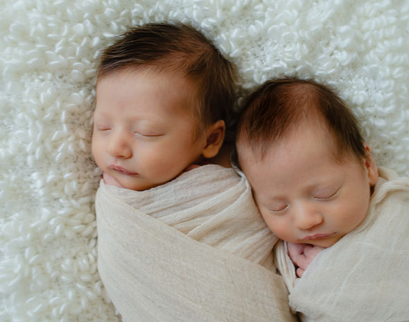 Neugeborene Zwillinge kuscheln und schlafen.