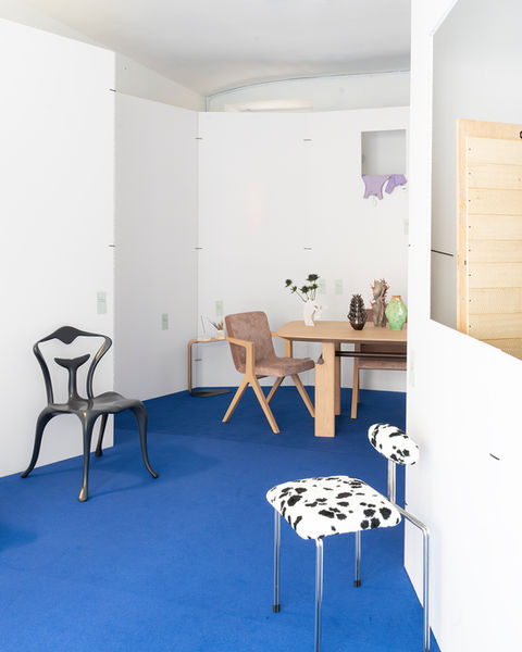 Design exhibition in a white room with a blue floor