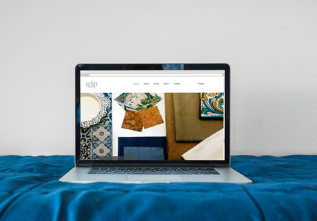 laptop on a bed with a website open