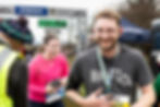 “Male runner holding his finisher medal after completing the Mackenzie Half Marathon.”