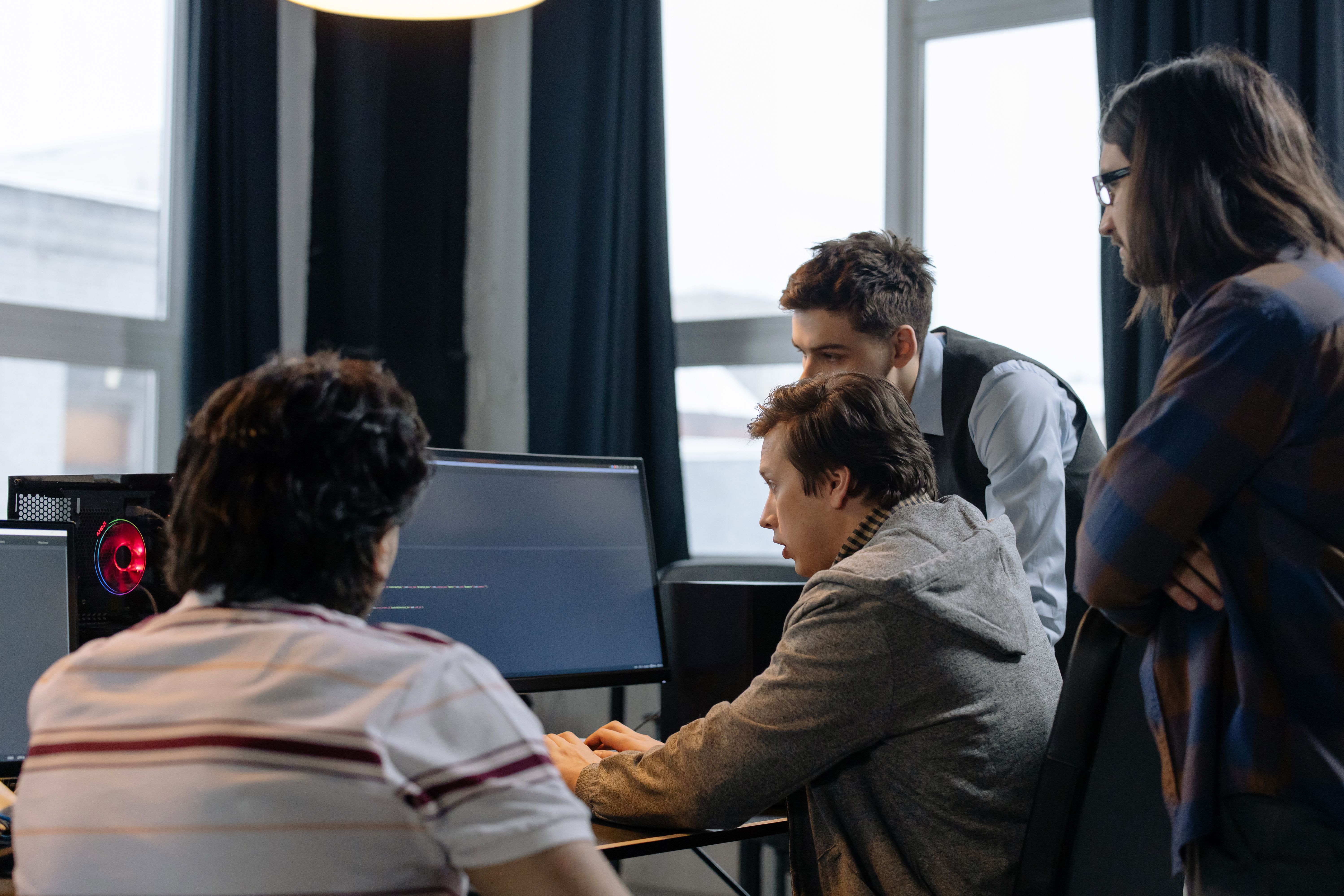Production team collaborating at a computer during a performance workflow