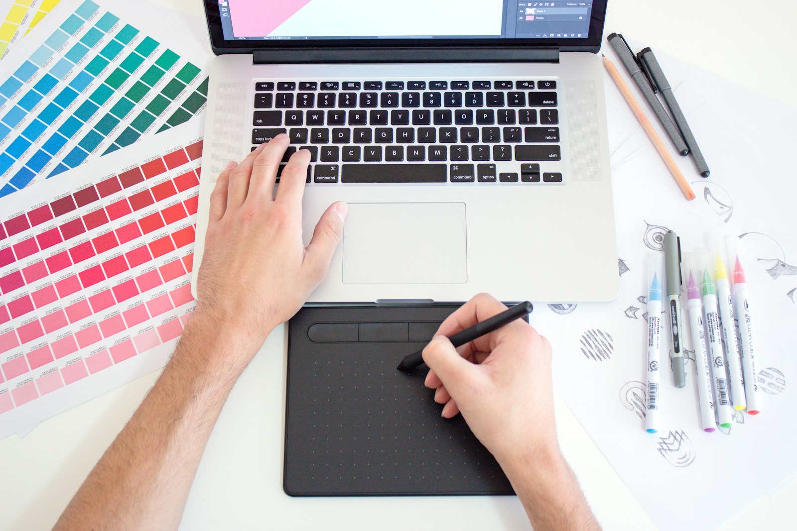 Designer working with a drawing tablet and laptop