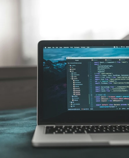 Laptop displaying code on a dark desk