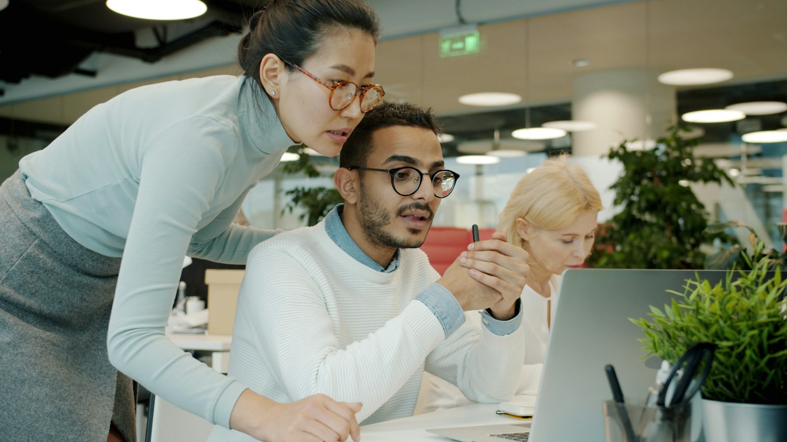 Team collaborating around a computer in an office