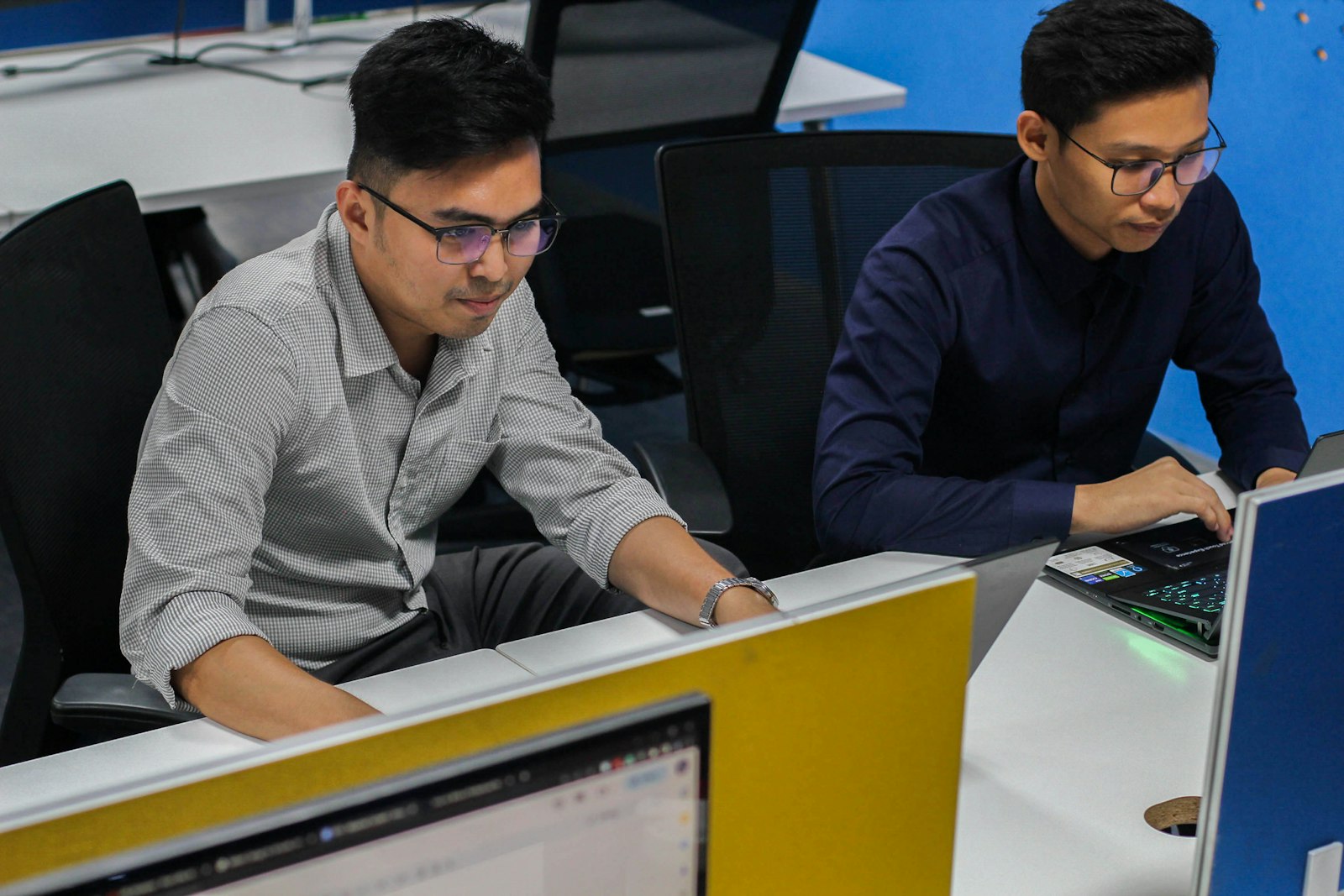Two production teammates working at computers