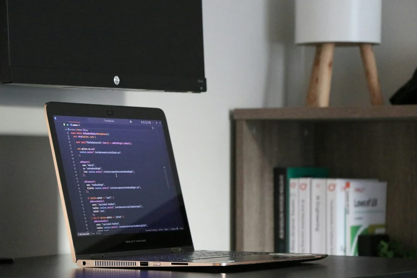 Laptop displaying software code on a desk