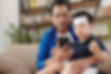 Parent with toddler in lap trying to make sense of what he is reading on his phone.