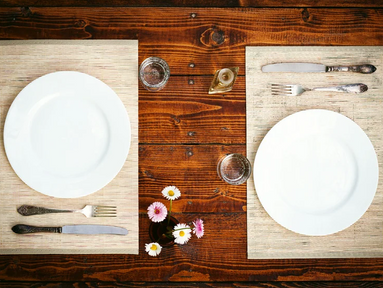 A restaurant table with two empty place settings.