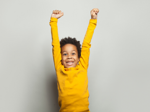 A young boy raising his arms in the air