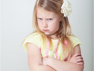 A young girl crossing her arms and looking mad
