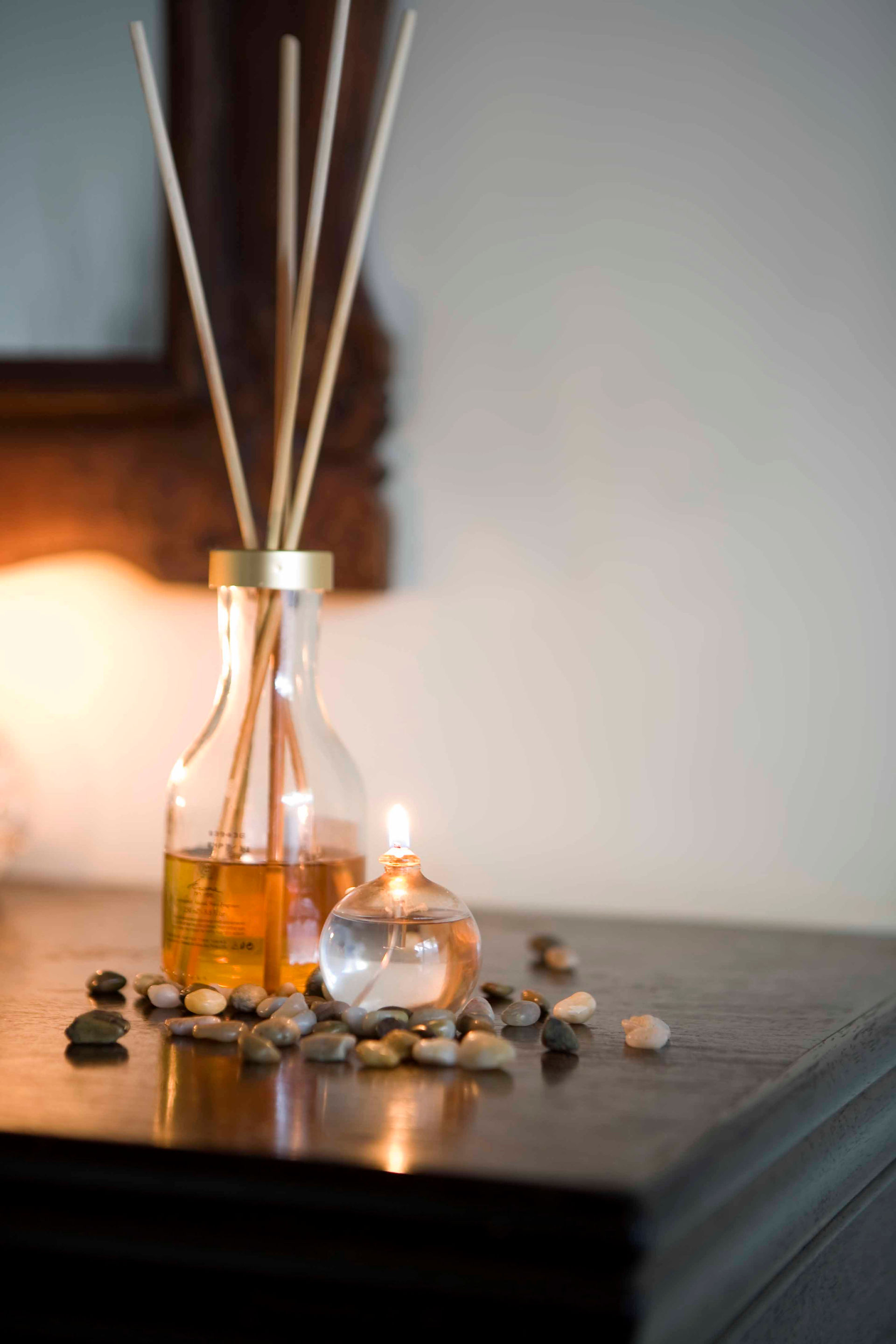 Reed diffuser with essential oils and candle on a side table in a luxury London interior, creating a calming biophilic sensory atmosphere.