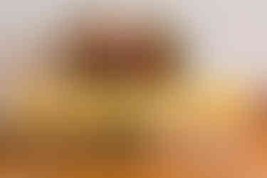 7 personalised wedding champagne flutes filled with bucks fizz, lined up on a table with a bouquet of red roses behind them