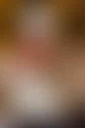 Three tier wedding cake decorated with red, white and pink flowers. Top and bottom cake have white icing and the middle tier has red icing