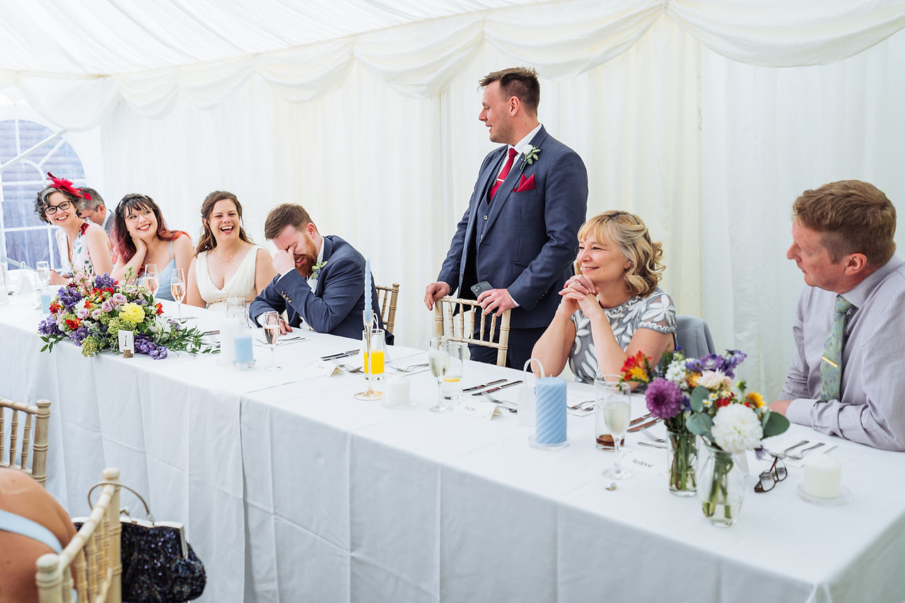 The top table laugh at the best man's wedding speech