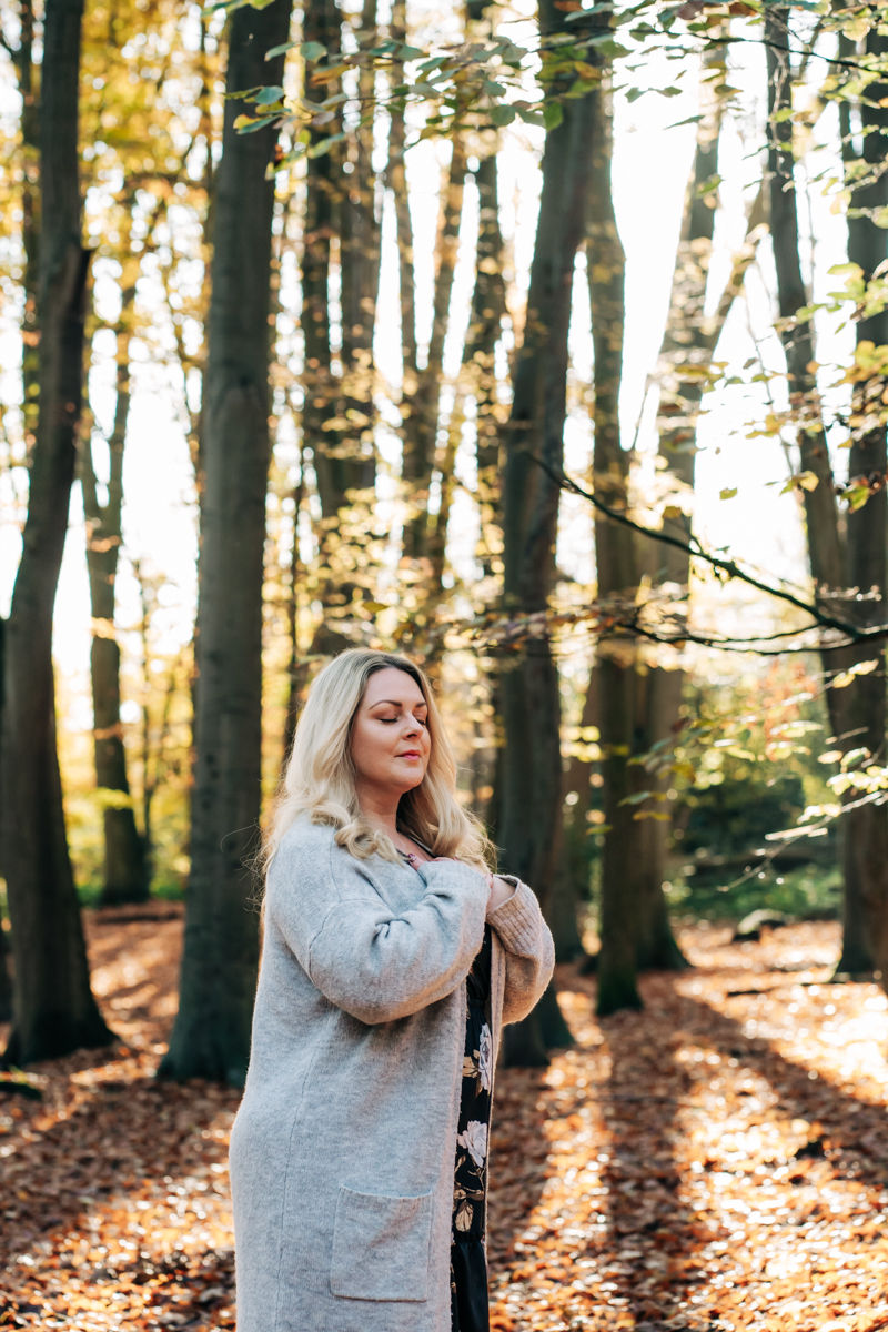 Sophia meditating peacefully in the sunlit woodland