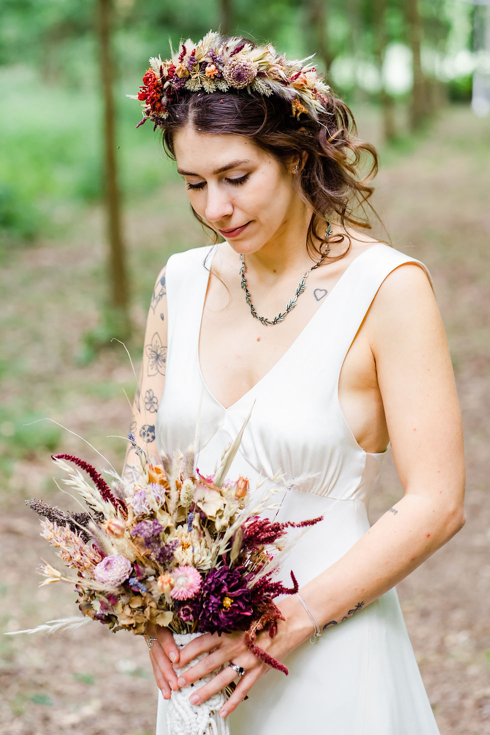 Bride wearing a dried flower crown, looking down at her dried flower buoquet