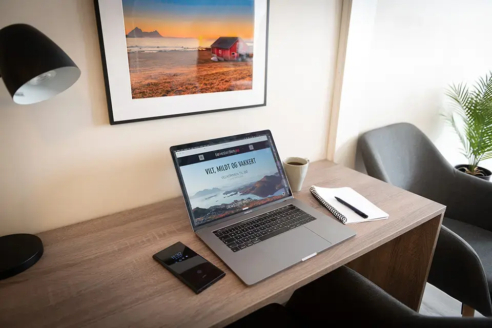 Laptop, mobil på skrivebord. Skjerm viser 'VET DU HVOR DU SKAL?'