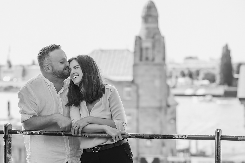 Paar um die Dreißig in Hamburg über dem alten Elbtunnel vor der Elbphilharmonie, schwarzweiß, beide Lächeln