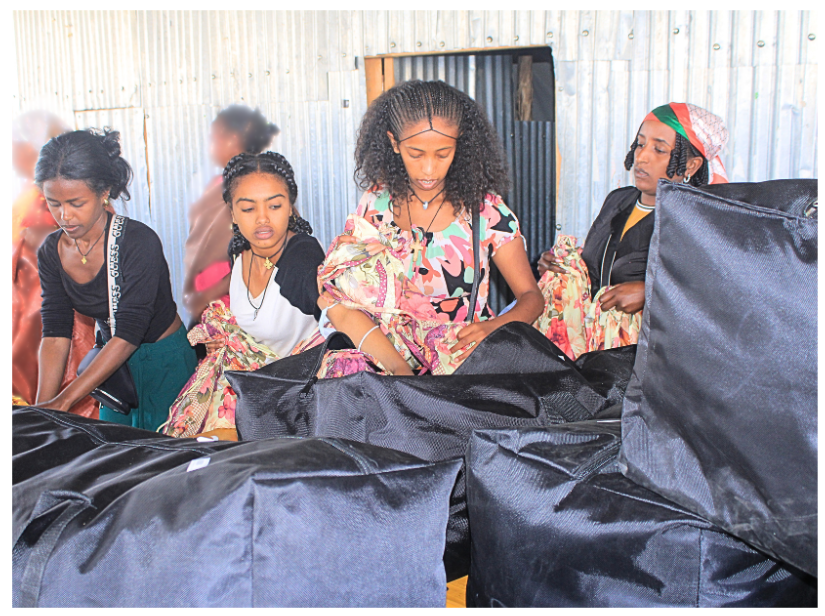 Studio Samuel MHM Student Ambassadors [middle] alongside staff, unpack menstrual kits to prepare for their first menstrual health presentation in a crisis zone.