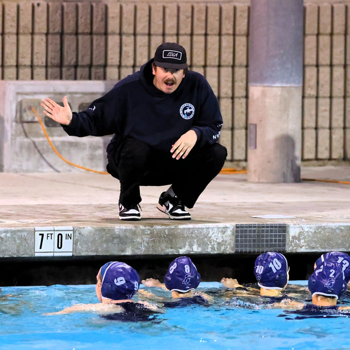 Coach instructing water polo team